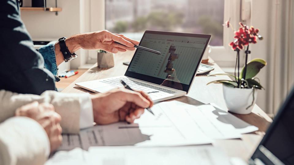 A businessman sits at a desk and analyzes the project timeline.