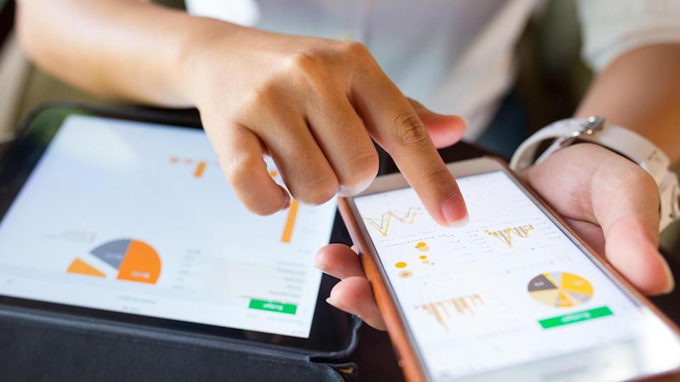 The businesswoman checks the data in the smartphone and tablet.